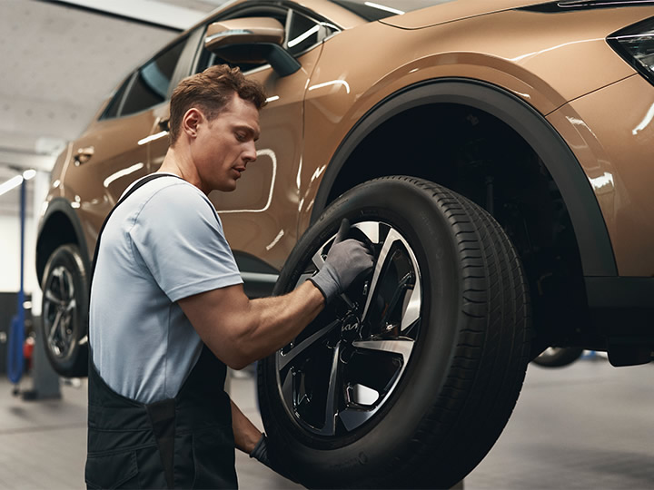 Mechanic shows the customer a genuine part from Kia