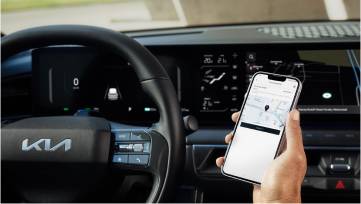 Driver with Kia Connect app on smartphone in EV9 interior